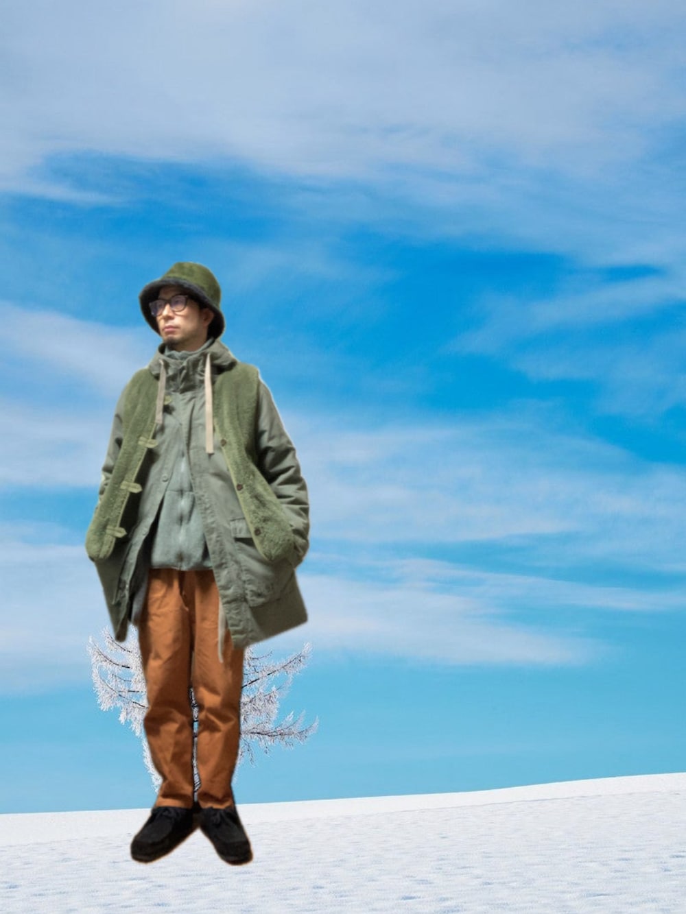 ブラウン系のチノパンツ、ブラック系のモカシン/デッキシューズ、グリーン系のモッズコートを着用したメンズの冬コーディネートの3枚目の写真