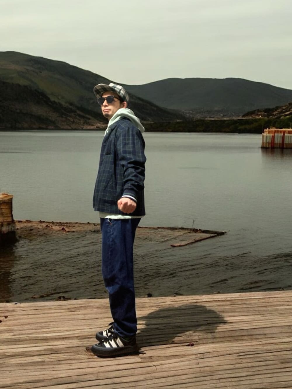 ブラック系のスニーカー、ブルー系のその他アウター、グリーン系のパーカーを着用したメンズの春コーディネートの2枚目の写真