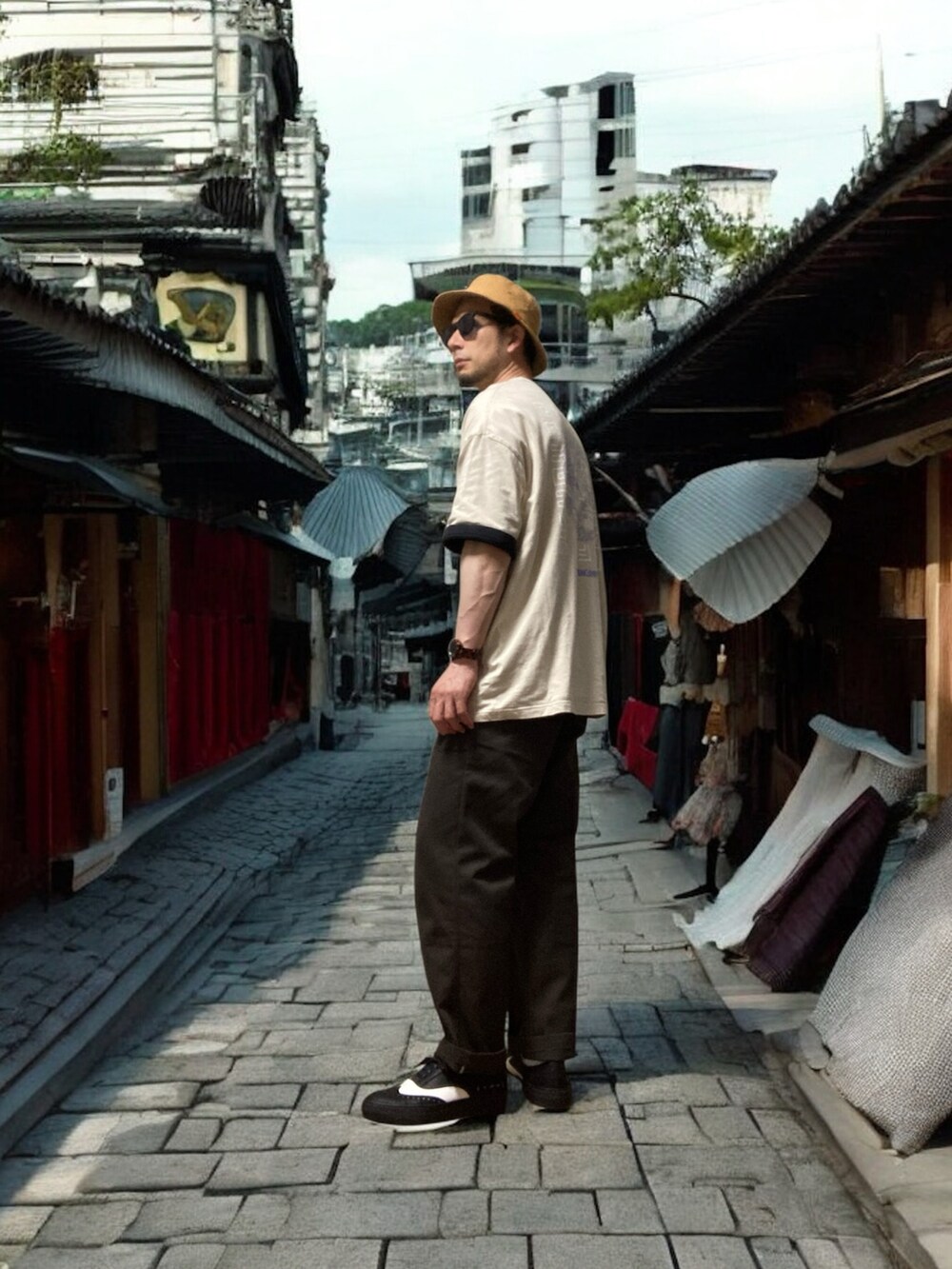 ブラウン系のチノパンツ、ベージュ系のTシャツ/カットソー、ブラック系のスニーカーを着用したメンズの夏コーディネートの3枚目の写真