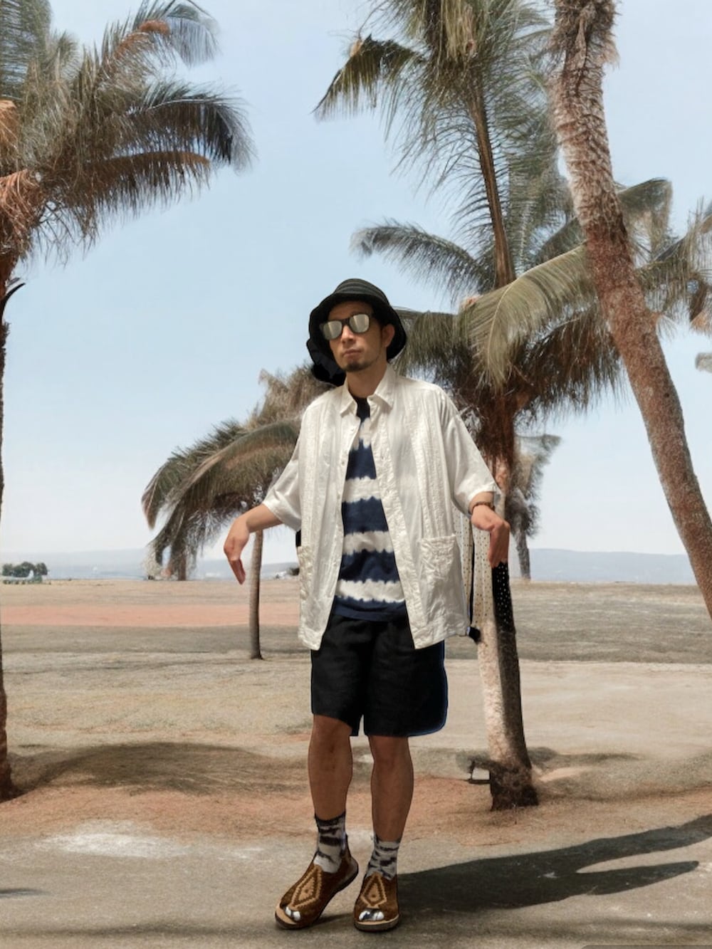 ブラウン系のサンダル、ブラック系のその他パンツ、ブルー系のTシャツ/カットソーを着用したメンズの夏コーディネートの5枚目の写真