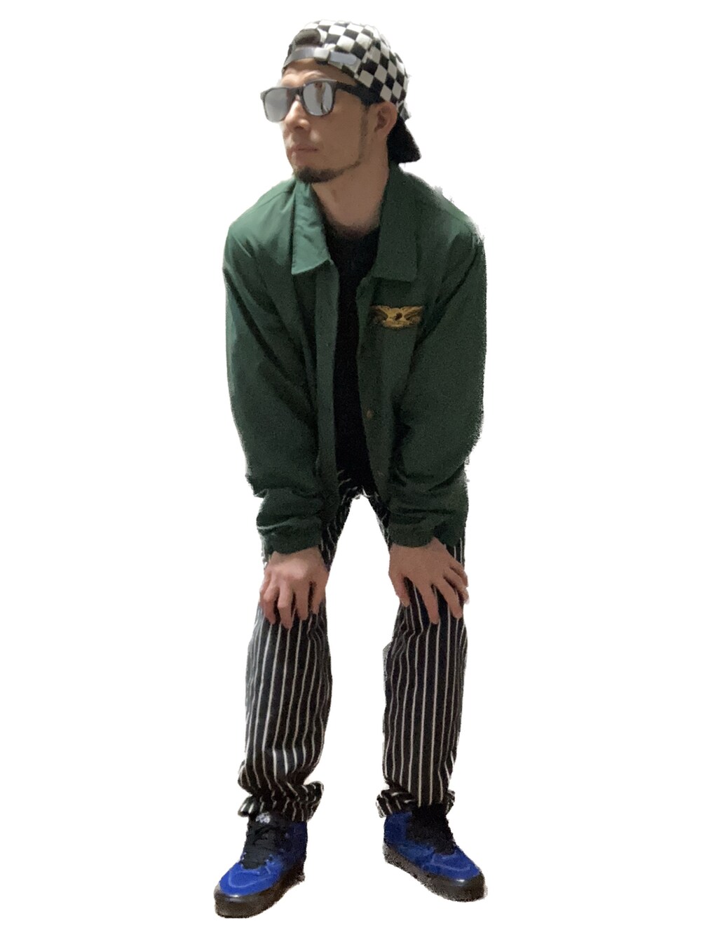 ブラック系のチノパンツ、ブルー系のスニーカー、グリーン系のナイロンジャケットを着用したメンズの秋コーディネートの3枚目の写真