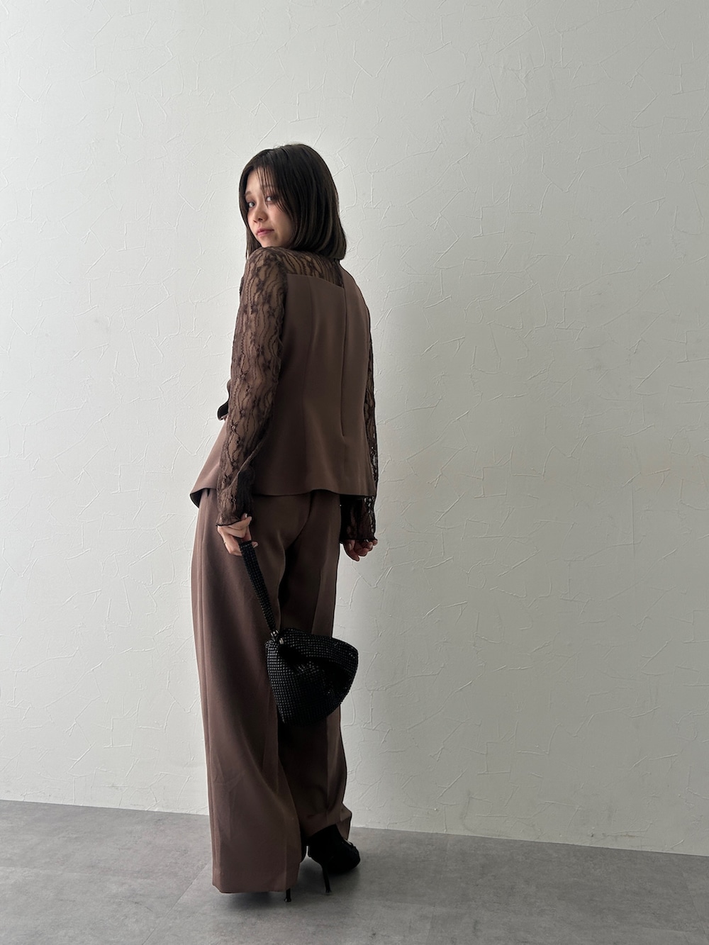 ブラウン系のパンツドレスを着用したレディースの秋コーディネートの2枚目の写真