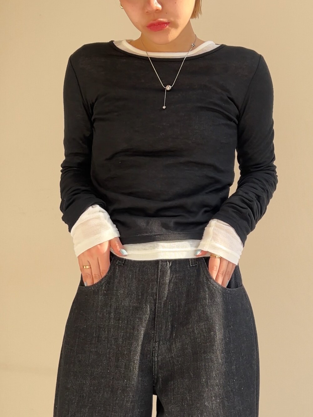 ホワイト系のTシャツ/カットソー、ブラック系のTシャツ/カットソー、ブラック系のデニムパンツを着用したレディースの春コーディネートの3枚目の写真