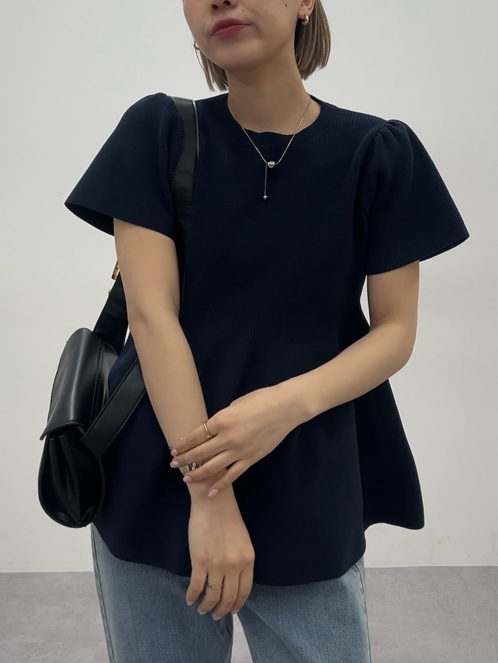 ブルー系のデニムパンツ、ブルー系のニット/セーター、ブルー系のデニムパンツを着用したレディースの春コーディネートの3枚目の写真