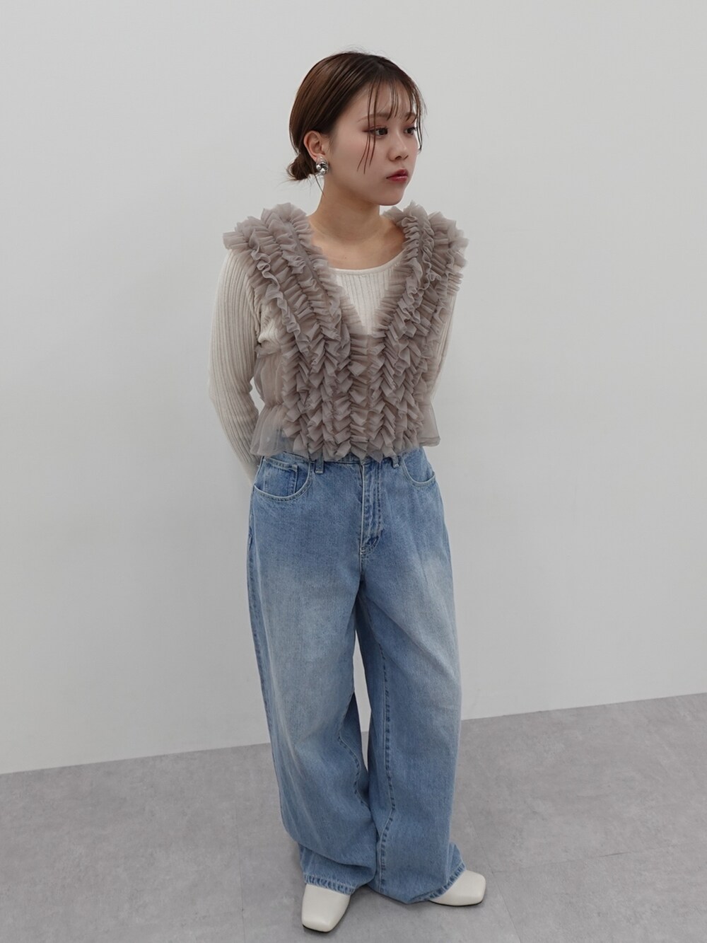 ベージュ系のベスト、ブルー系のデニムパンツ、ブルー系のデニムパンツを着用したレディースの冬コーディネートの3枚目の写真