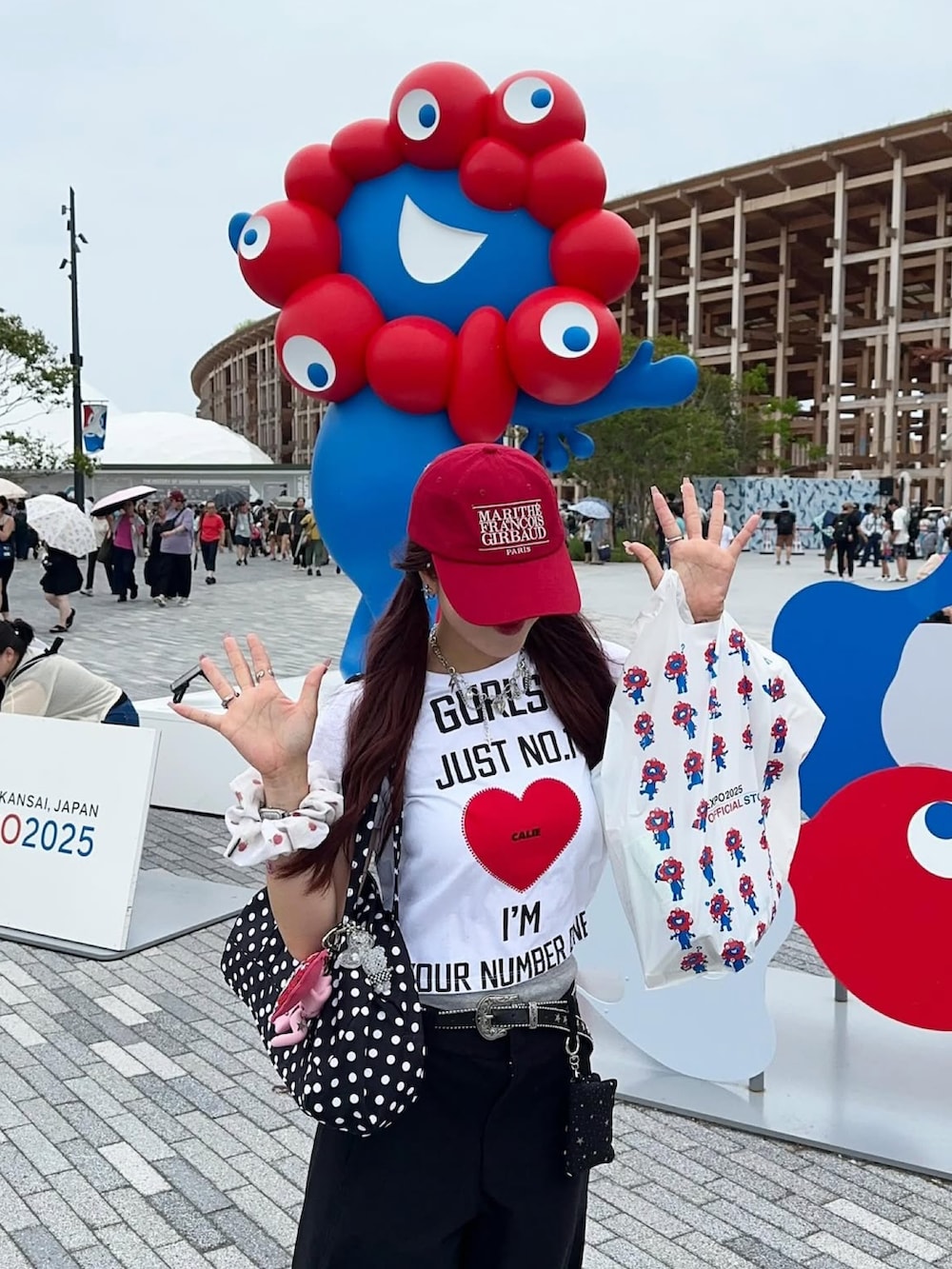 ホワイト系のサンダル、ブラック系のパンツ、レッド系のキャップを着用したレディースの夏コーディネートの2枚目の写真