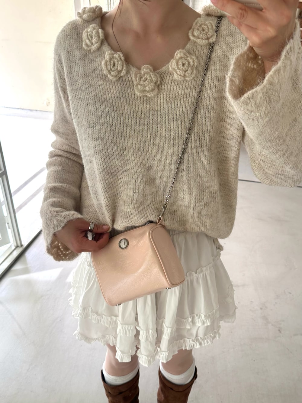 ブラウン系のブーツ、ベージュ系のトップス、ホワイト系のスカートを着用したレディースの春コーディネートの3枚目の写真