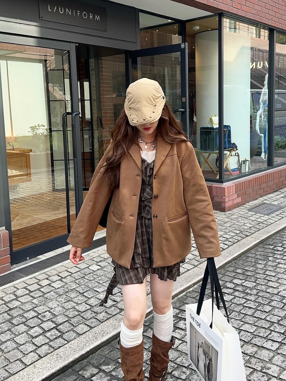 イエロー系のテーラードジャケット、ブラウン系のブーツ、ブラウン系のワンピース/ドレスを着用したレディースの秋コーディネートの4枚目の写真