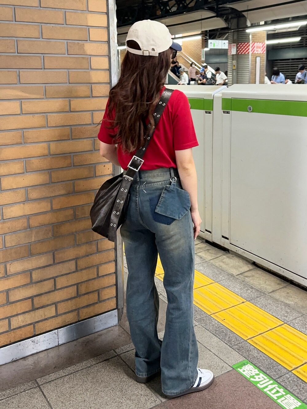 レッド系のTシャツ/カットソー、ブルー系のデニムパンツ、ブラウン系のショルダーバッグを着用したレディースの夏コーディネートの2枚目の写真