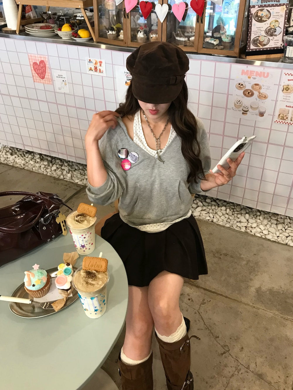グレー系のパーカー、その他のスカート、ブラウン系のブーツを着用したレディースの秋コーディネートの2枚目の写真