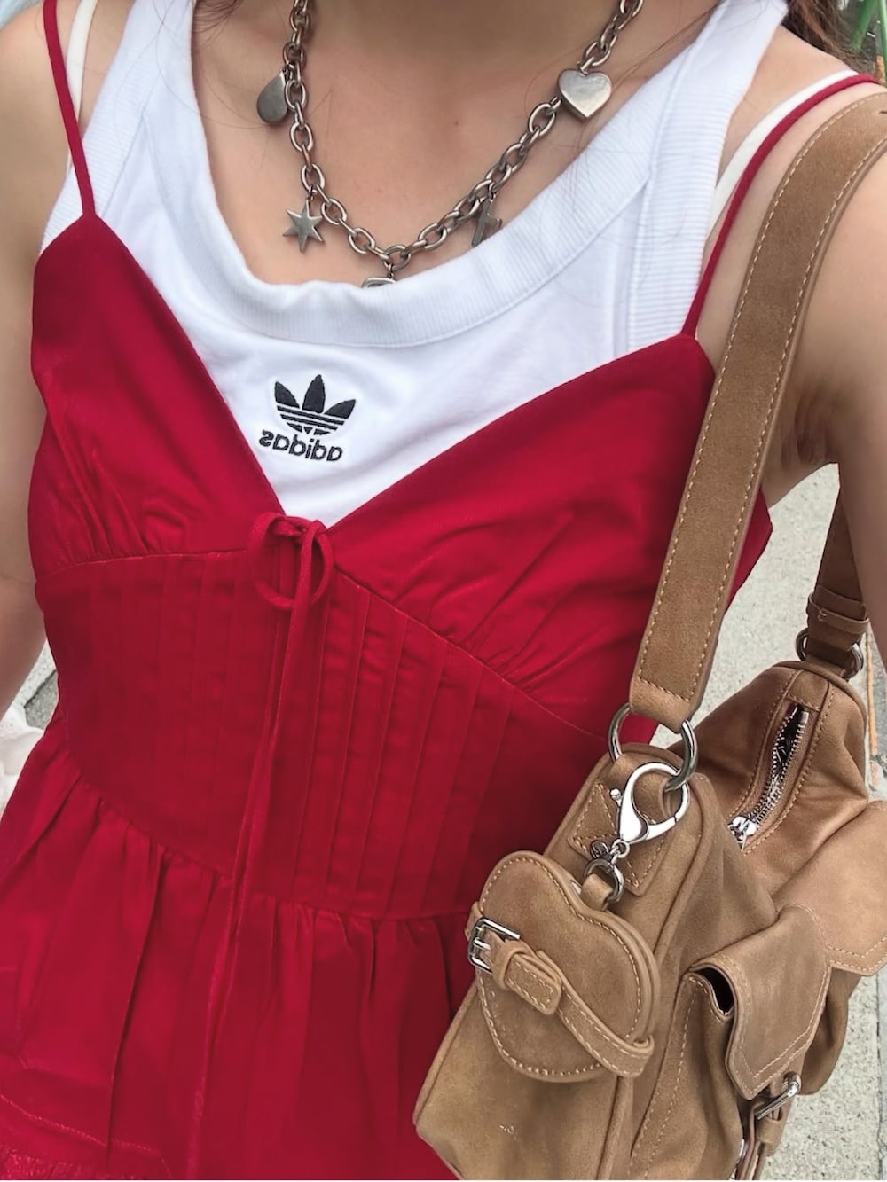 レッド系のワンピース、ベージュ系のカーゴパンツ、ホワイト系のスニーカーを着用したレディースの夏コーディネートの2枚目の写真