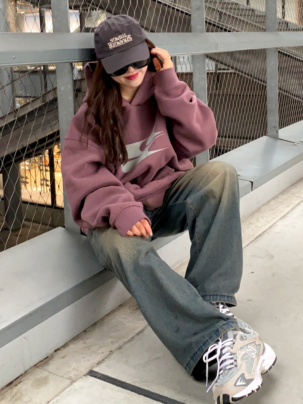 ブルー系のデニムジャケット、グレー系のスニーカー、グレー系のキャップを着用したレディースの冬コーディネートの2枚目の写真