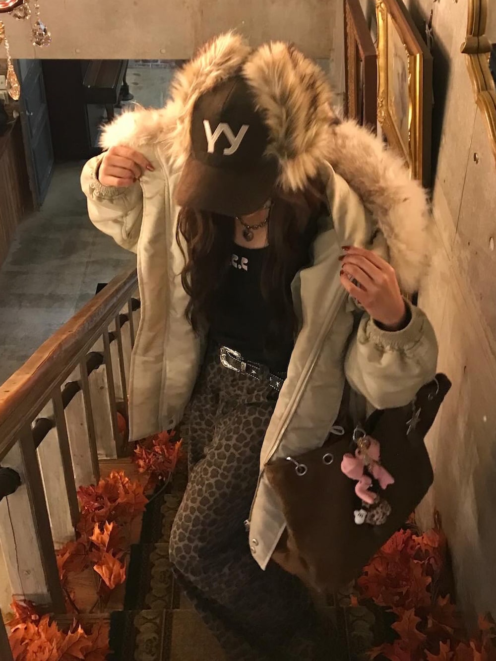 ホワイト系のブルゾン、ブラック系のTシャツ/カットソー、ブラウン系のパンツを着用したレディースの秋コーディネートの4枚目の写真