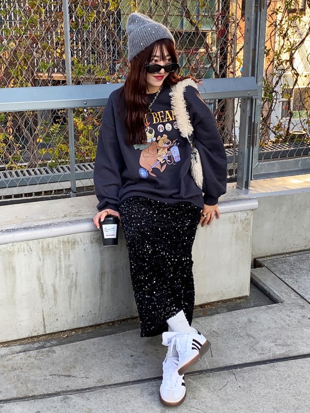 ブラック系のスカート、ホワイト系のショルダーバッグを着用したレディースの冬コーディネートの2枚目の写真