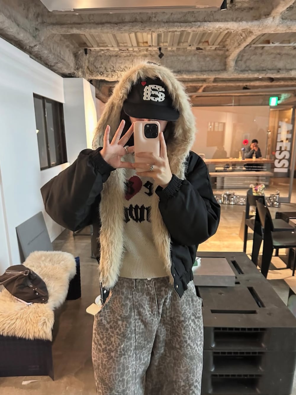 ホワイト系のニット/セーター、ブラウン系のブーツ、グレー系のデニムパンツを着用したレディースの秋コーディネートの3枚目の写真