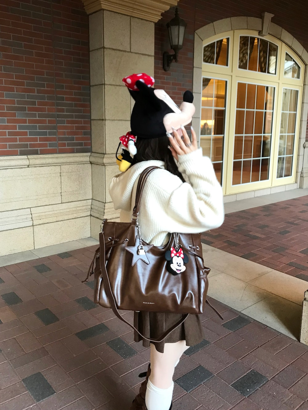 ブラウン系のブーツ、ホワイト系のニット/セーターを着用したレディースの冬コーディネートの3枚目の写真