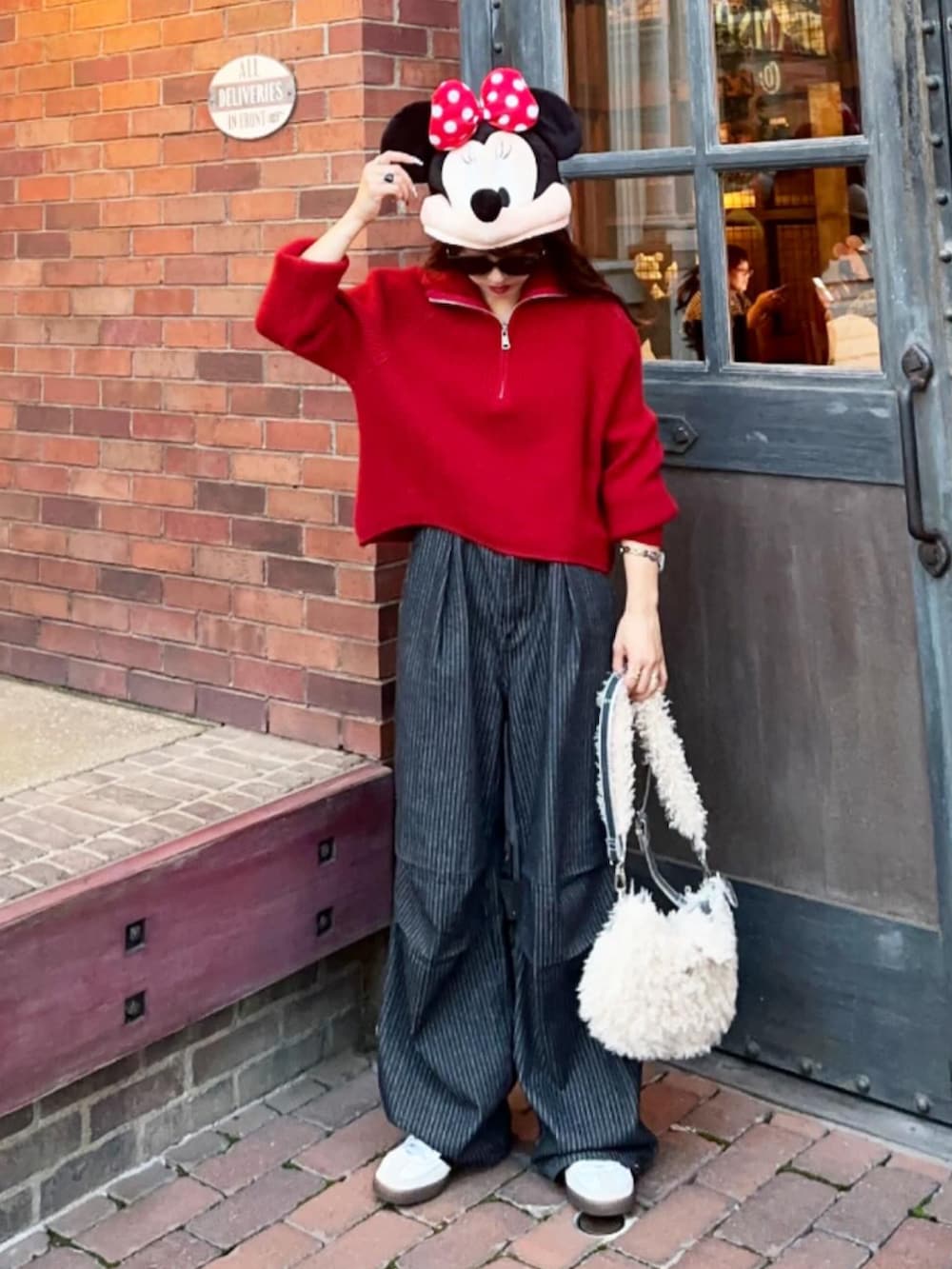 ブルー系のスウェット、ブラック系のデニムパンツ、ブラウン系のショルダーバッグを着用したレディースの秋コーディネートの2枚目の写真