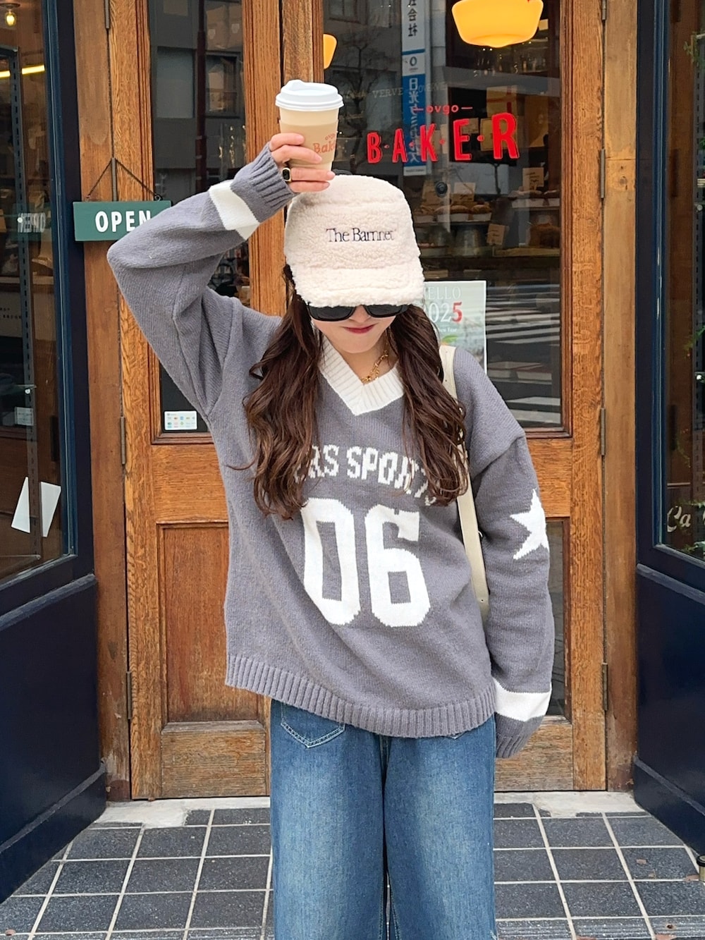 ブラック系のスニーカー、ベージュ系のハンドバッグを着用したレディースの冬コーディネートの2枚目の写真