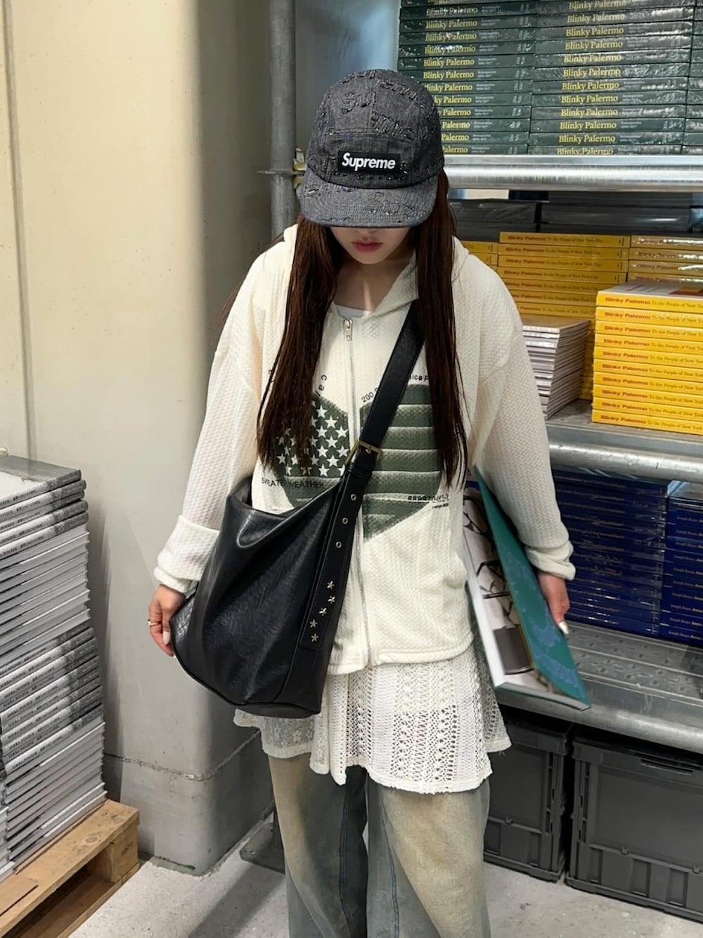 ブルー系のデニムパンツ、ホワイト系のパーカー、ブラック系のショルダーバッグを着用したレディースの春コーディネートの3枚目の写真