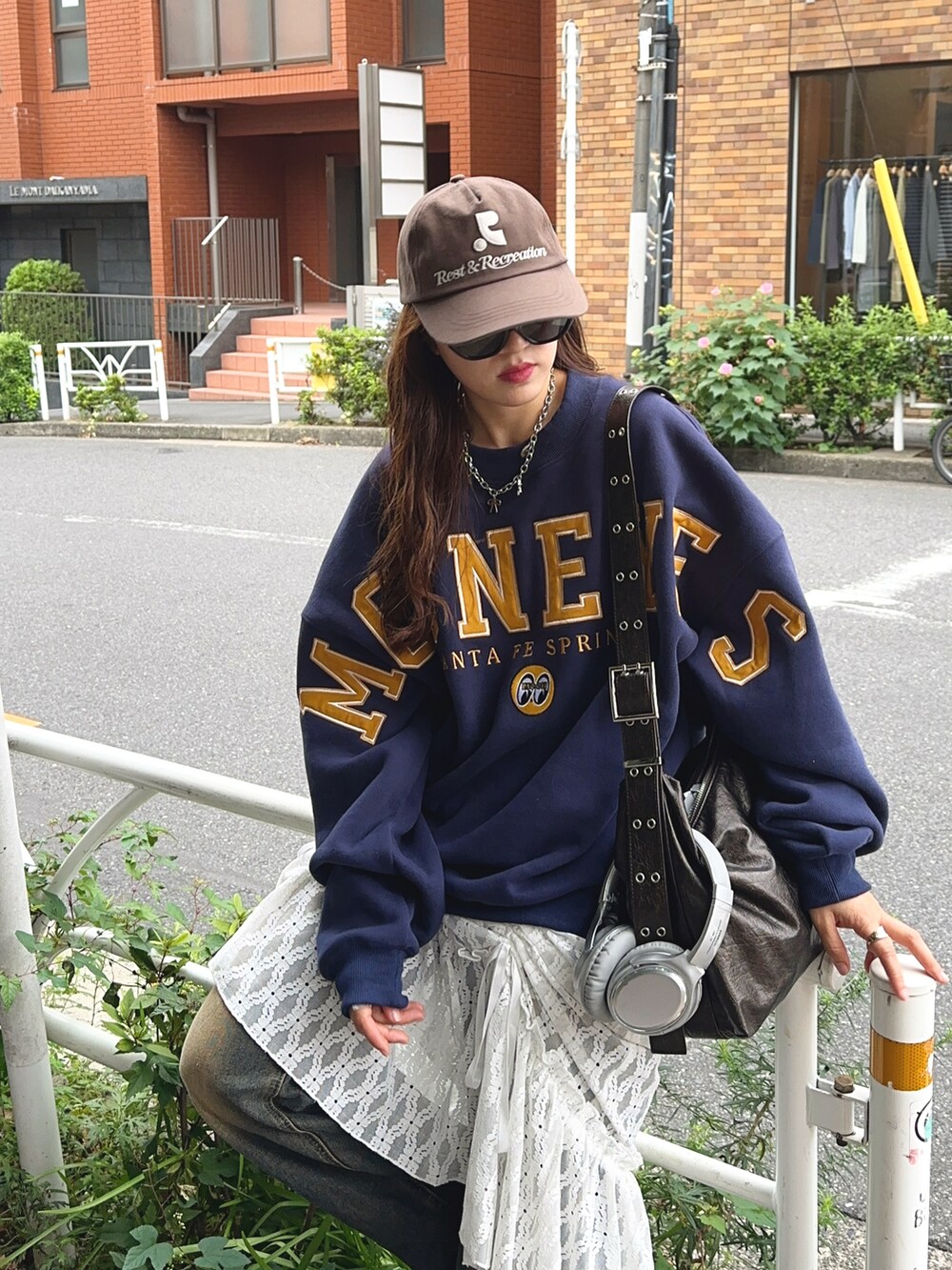 ブルー系のスウェット、ブルー系のデニムパンツ、イエロー系のスニーカーを着用したレディースの秋コーディネートの2枚目の写真