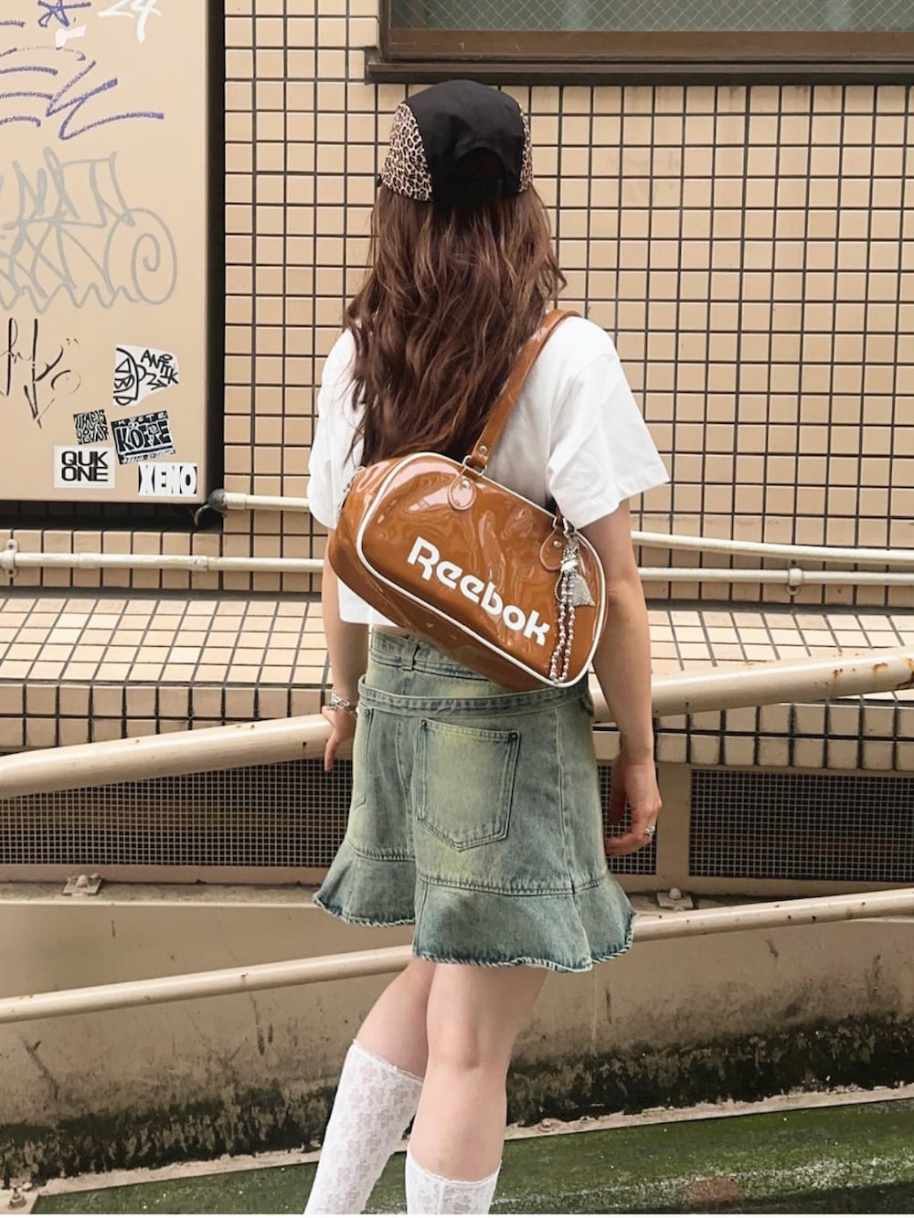 ホワイト系のサンダル、ブラウン系のボストンバッグ、ブルー系のデニムスカートを着用したレディースの春コーディネートの2枚目の写真