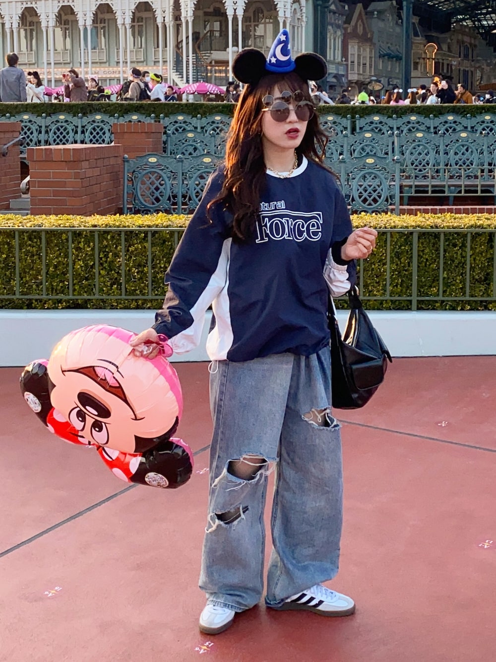 ホワイト系のスニーカー、ブルー系のトップス、ブルー系のデニムパンツを着用したレディースの秋コーディネートの4枚目の写真