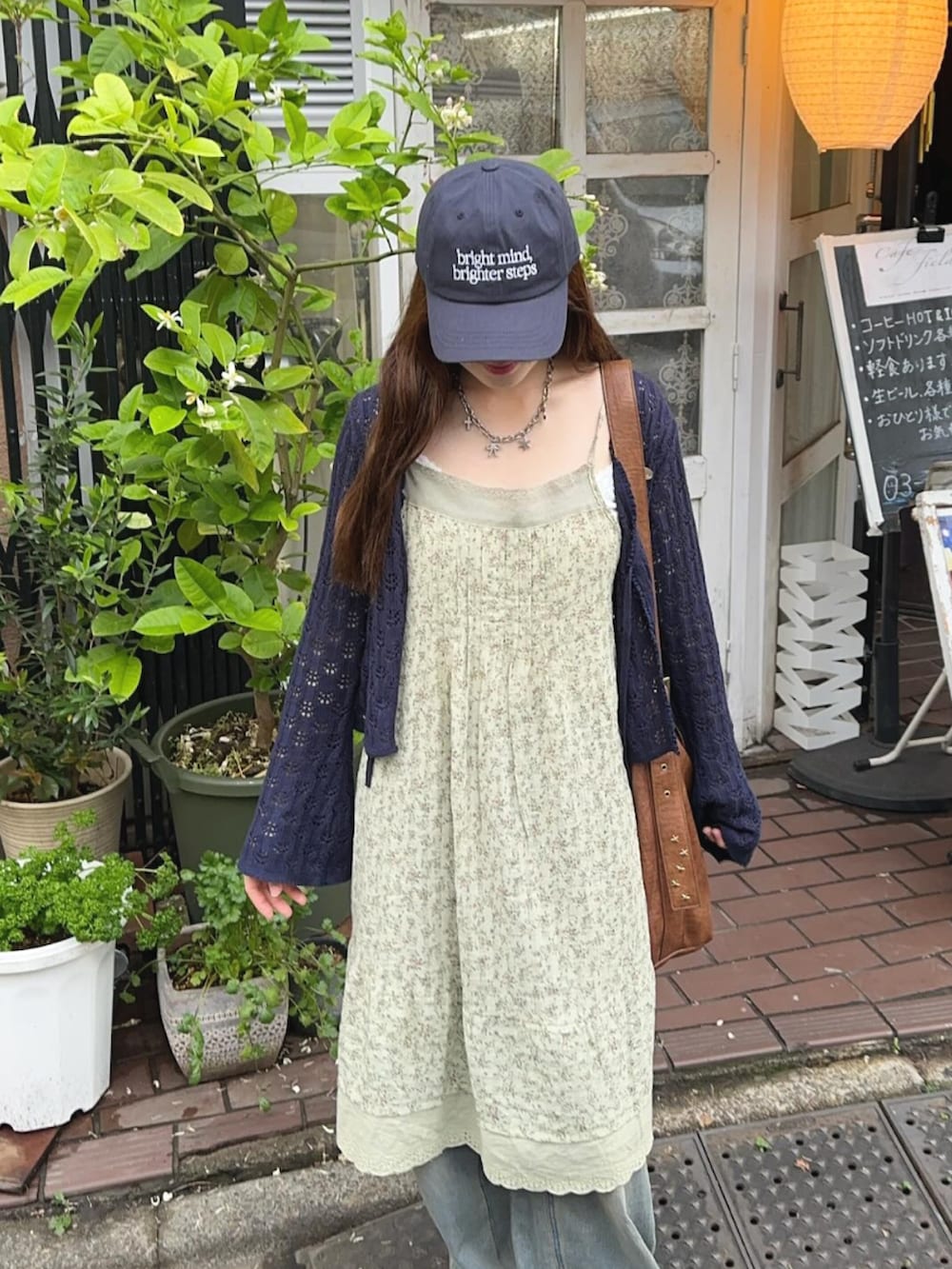 ブルー系のカーディガン/ボレロ、ブルー系のデニムパンツ、ブラウン系のショルダーバッグを着用したレディースの春コーディネートの4枚目の写真