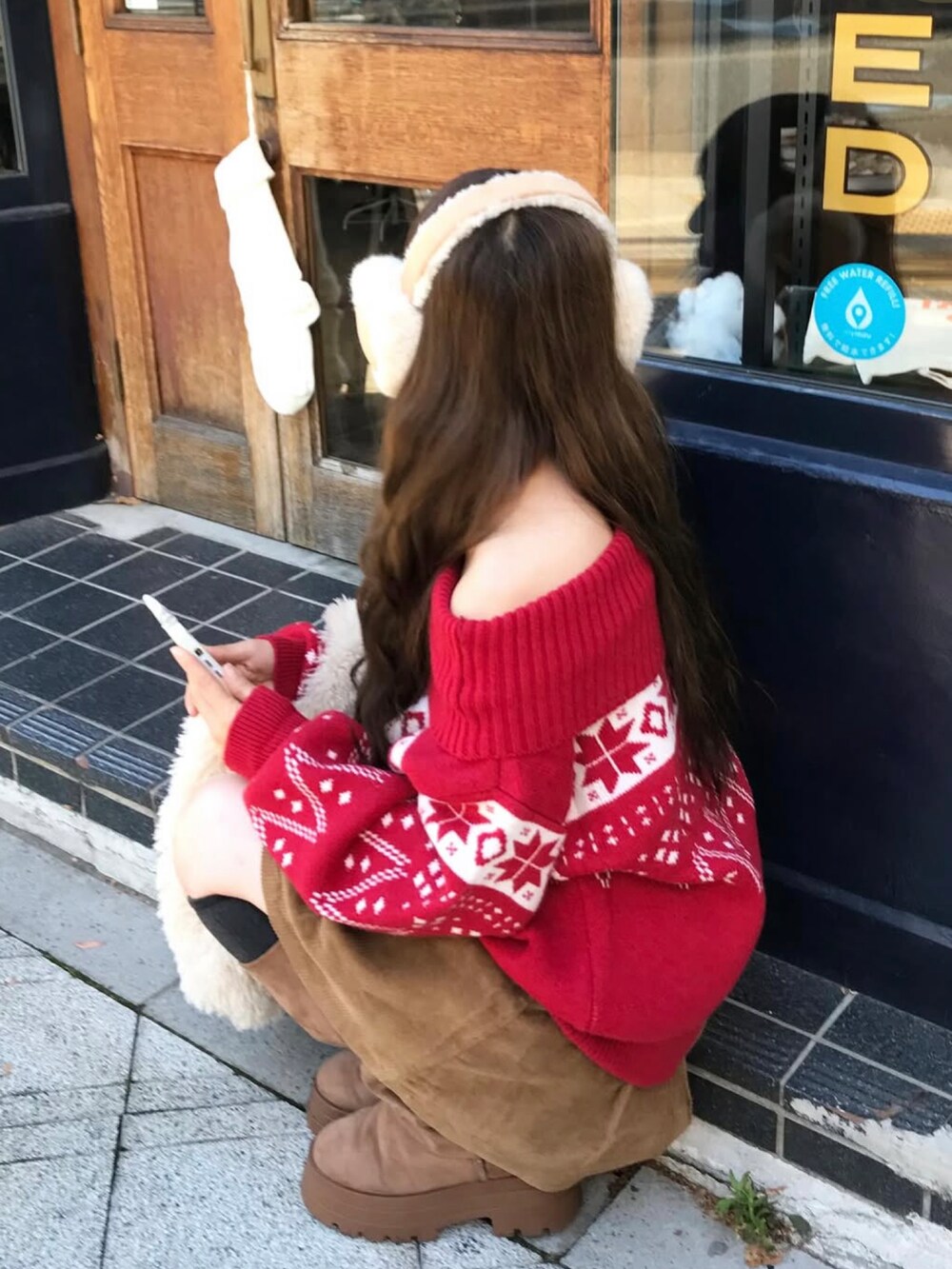 ブラウン系のスカート、ブラウン系のブーツを着用したレディースの秋コーディネートの3枚目の写真