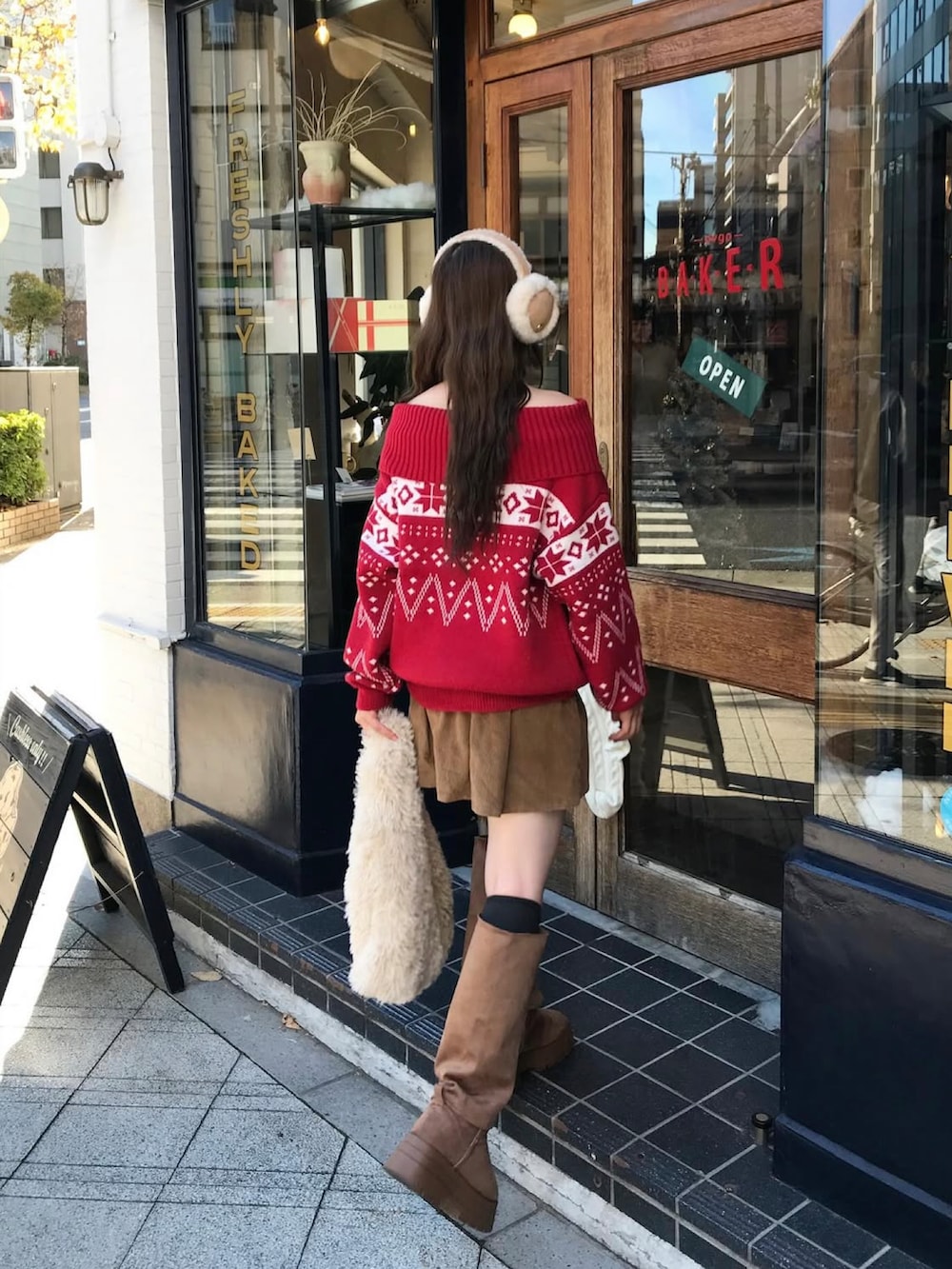 ブラウン系のスカート、ブラウン系のブーツを着用したレディースの秋コーディネートの2枚目の写真