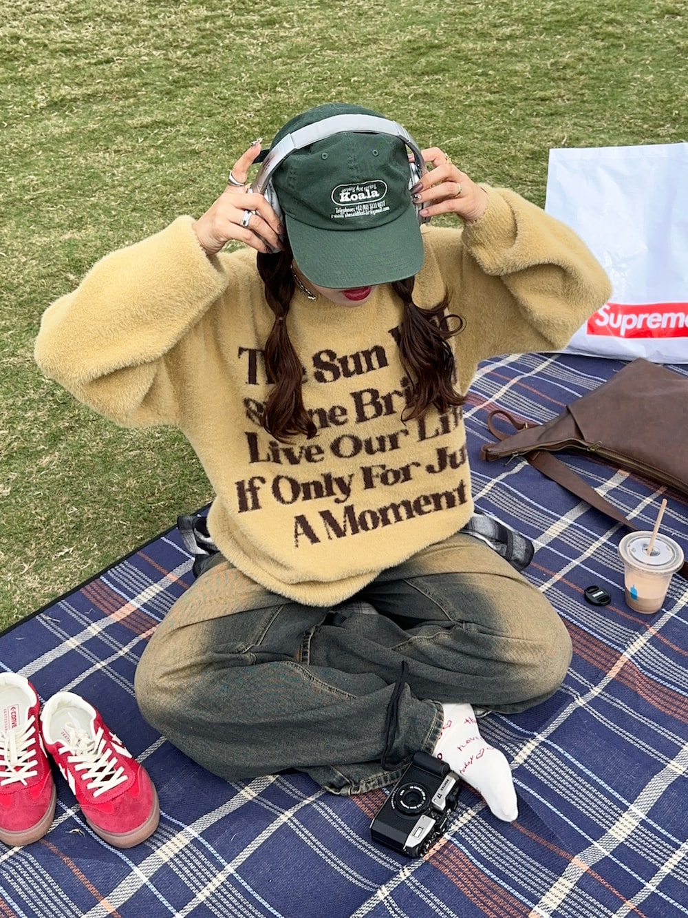 イエロー系のニット/セーター、ブラック系のシャツ/ブラウス、レッド系のスニーカーを着用したレディースの秋コーディネートの2枚目の写真