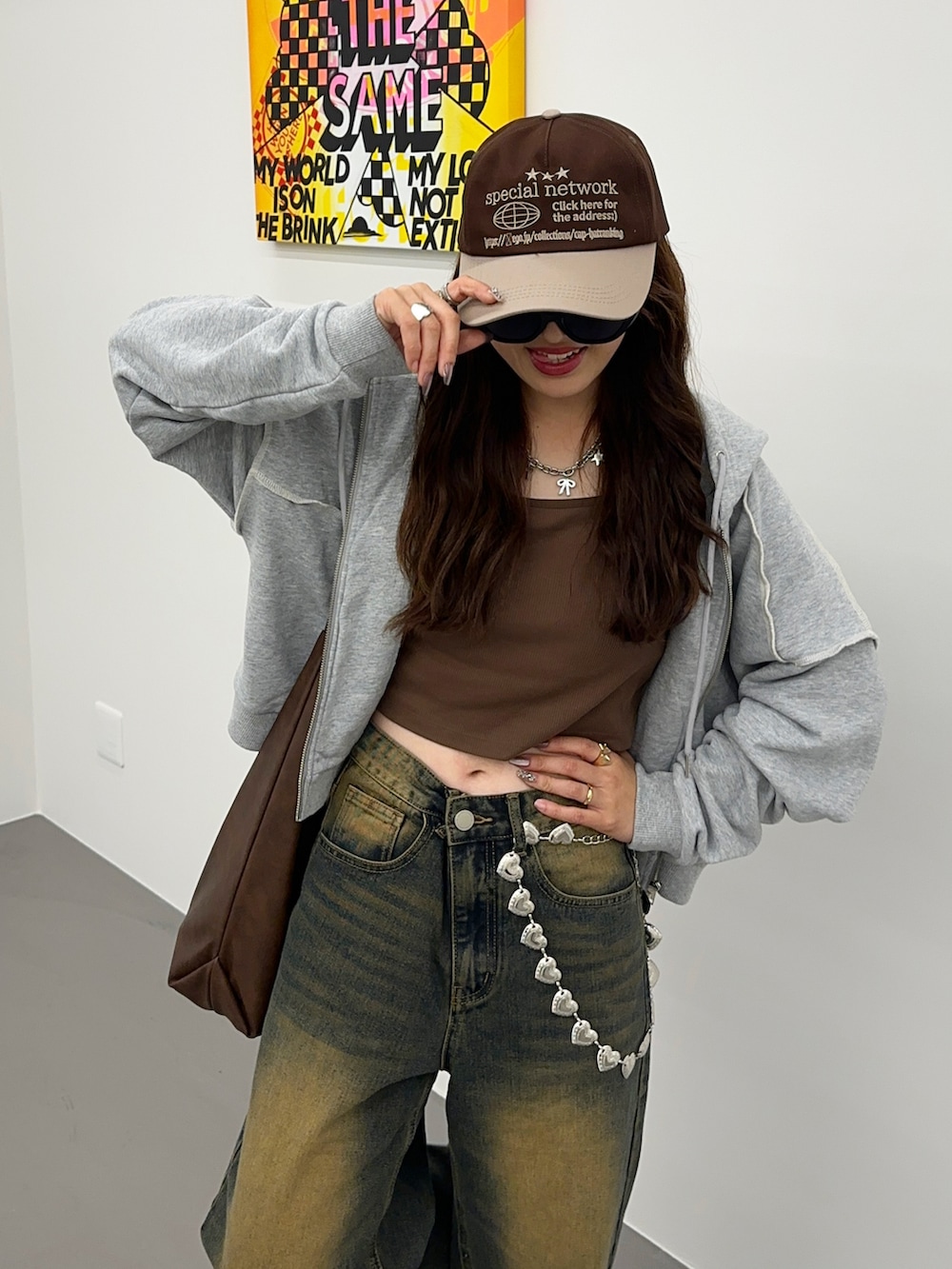 ブラウン系のキャミソール、ブルー系のデニムパンツ、グレー系のパーカーを着用したレディースの秋コーディネートの3枚目の写真