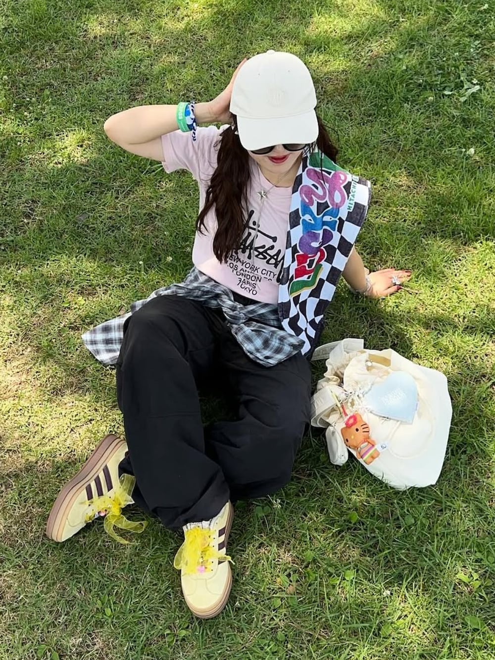 イエロー系のスニーカー、ブラック系のパンツ、ピンク系のトップスを着用したレディースの夏コーディネートの3枚目の写真