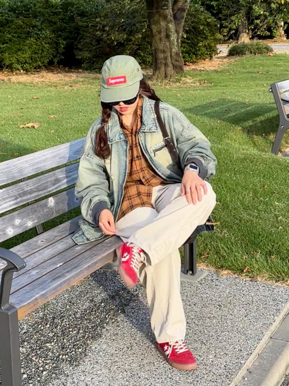 ブルー系のブルゾン、ベージュ系のパンツ、レッド系のスニーカーを着用したレディースの秋コーディネートの3枚目の写真