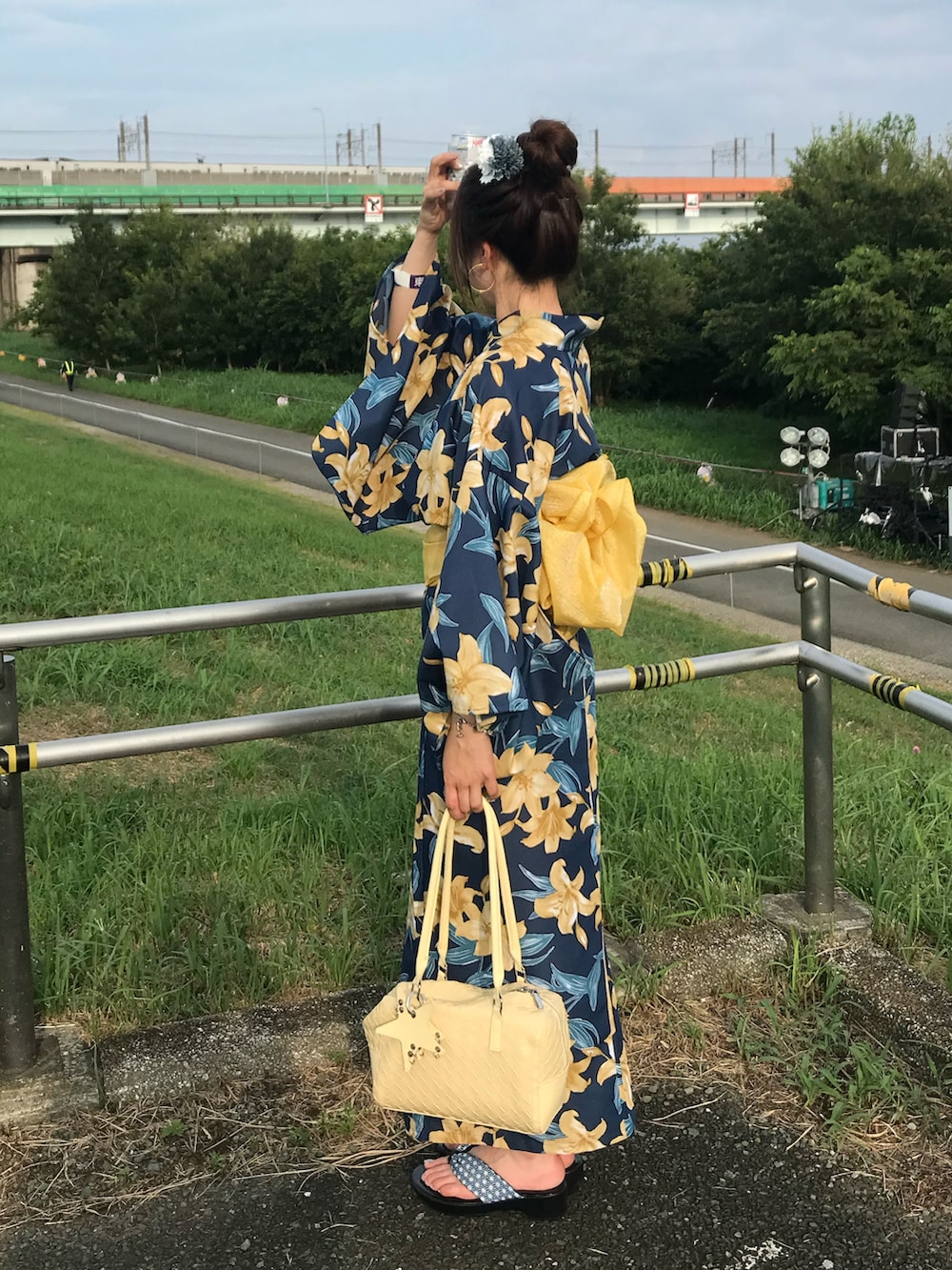イエロー系のバッグ、ブルー系のシューズ、ブルー系の浴衣を着用したレディースの夏コーディネートの2枚目の写真