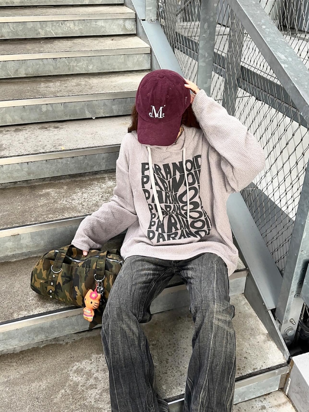 ブラック系のブーツ、グレー系のパーカー、その他のキャップを着用したレディースの秋コーディネートの2枚目の写真