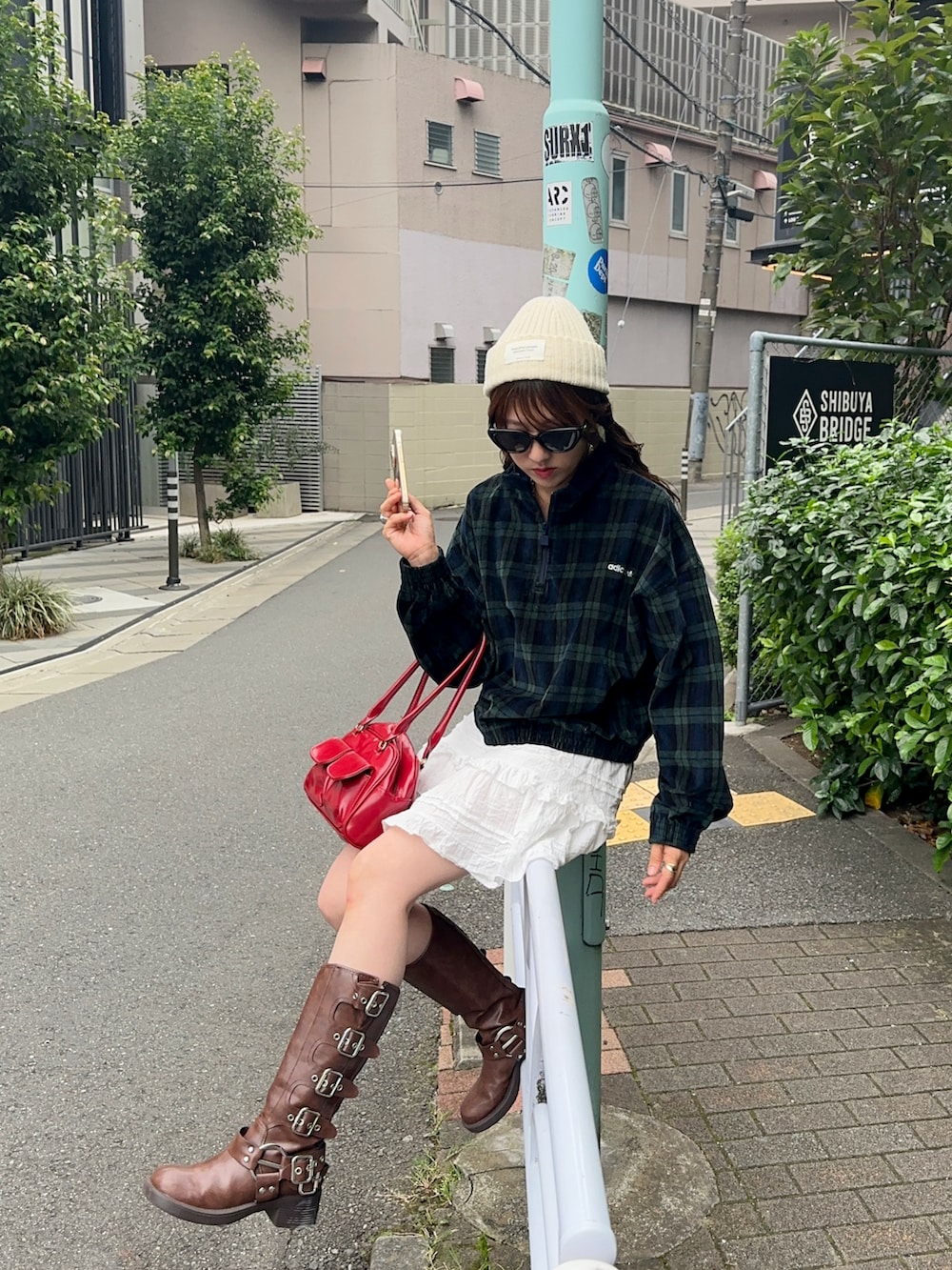 ブルー系のその他トップス、ホワイト系のスカート、ブラウン系のブーツを着用したレディースの秋コーディネートの4枚目の写真