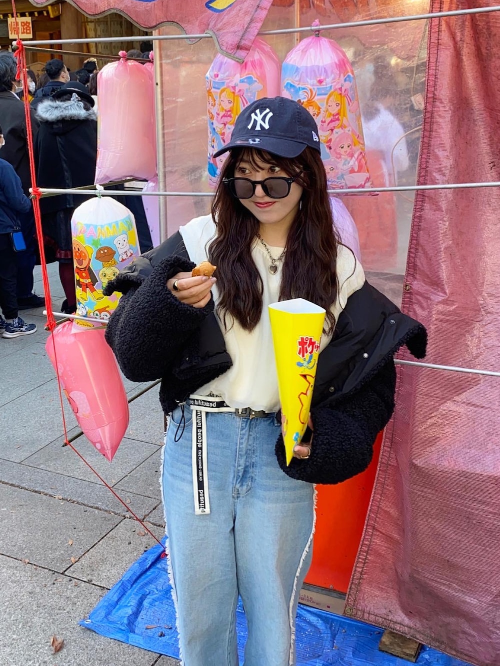 ブルー系のデニムパンツ、ホワイト系のスウェット、グレー系のスニーカーを着用したレディースの冬コーディネートの2枚目の写真