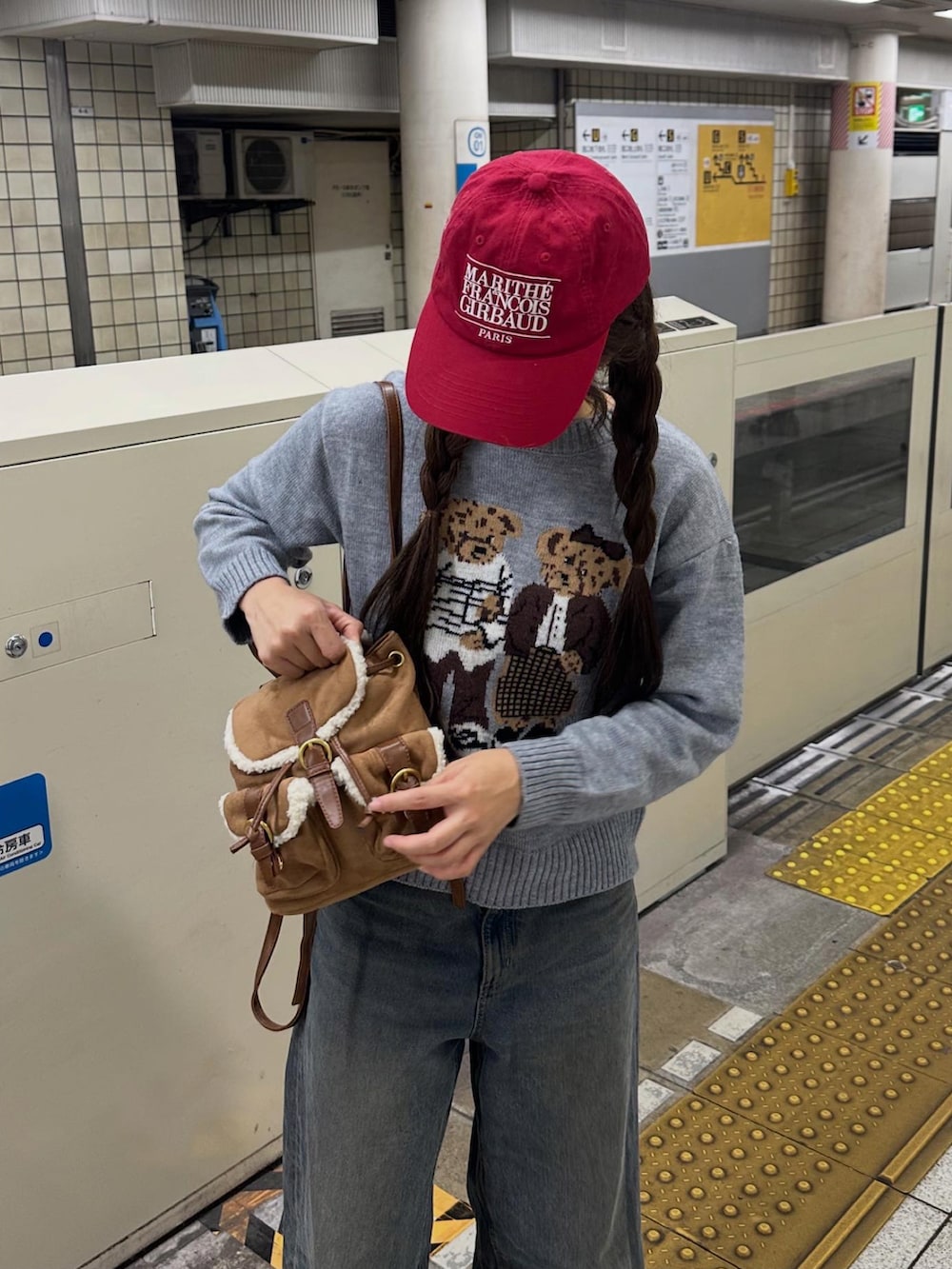 ブラウン系のブーツ、グレー系のニット/セーター、ブルー系のデニムパンツを着用したレディースの秋コーディネートの2枚目の写真