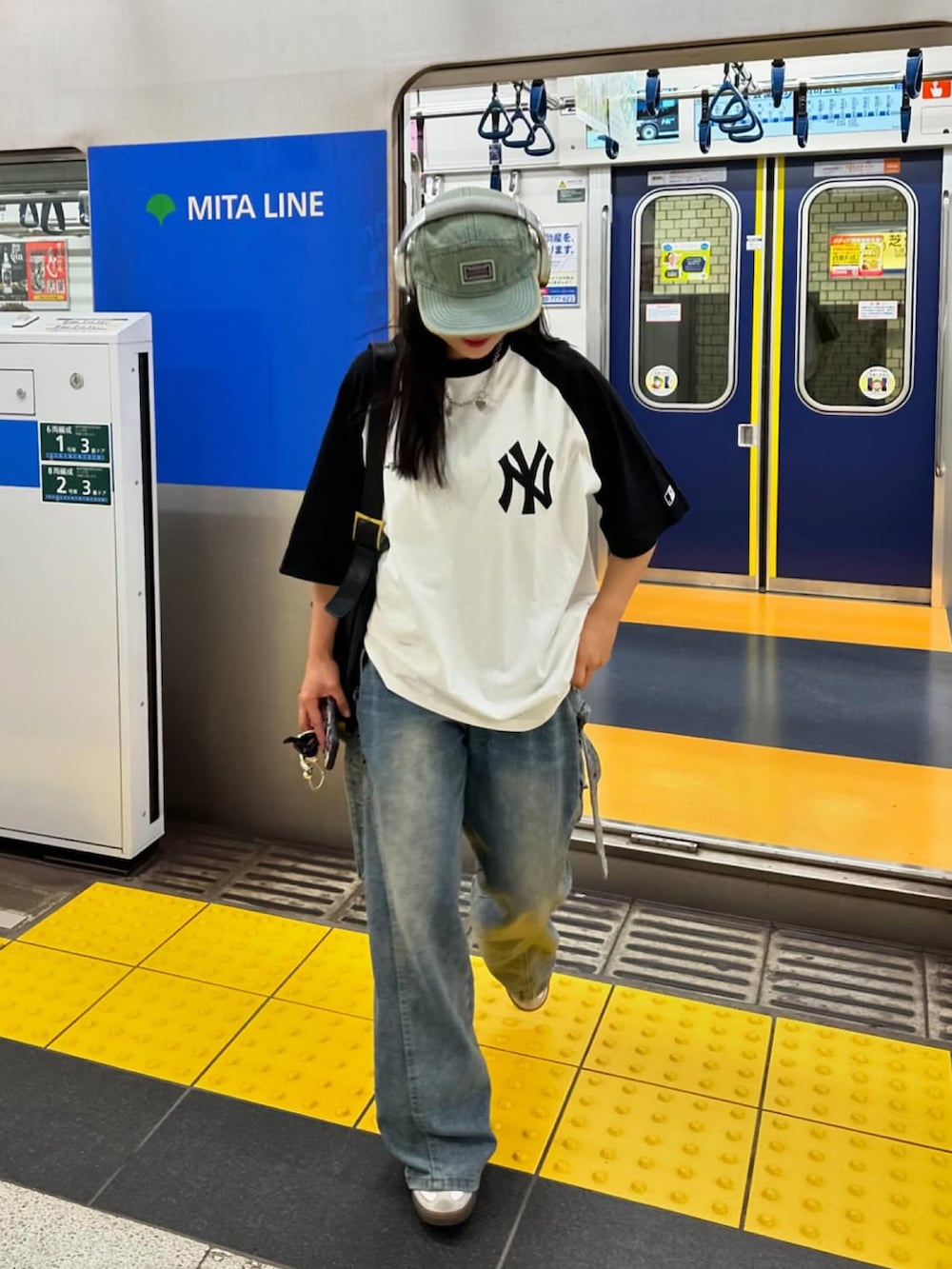 ホワイト系のTシャツ/カットソー、ホワイト系のスニーカー、ブルー系のキャップを着用したレディースの夏コーディネートの3枚目の写真