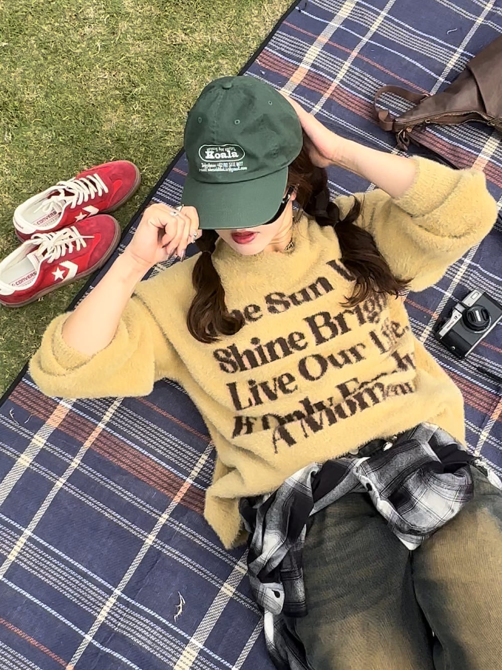 イエロー系のニット/セーター、ブラック系のシャツ/ブラウス、レッド系のスニーカーを着用したレディースの秋コーディネートの4枚目の写真