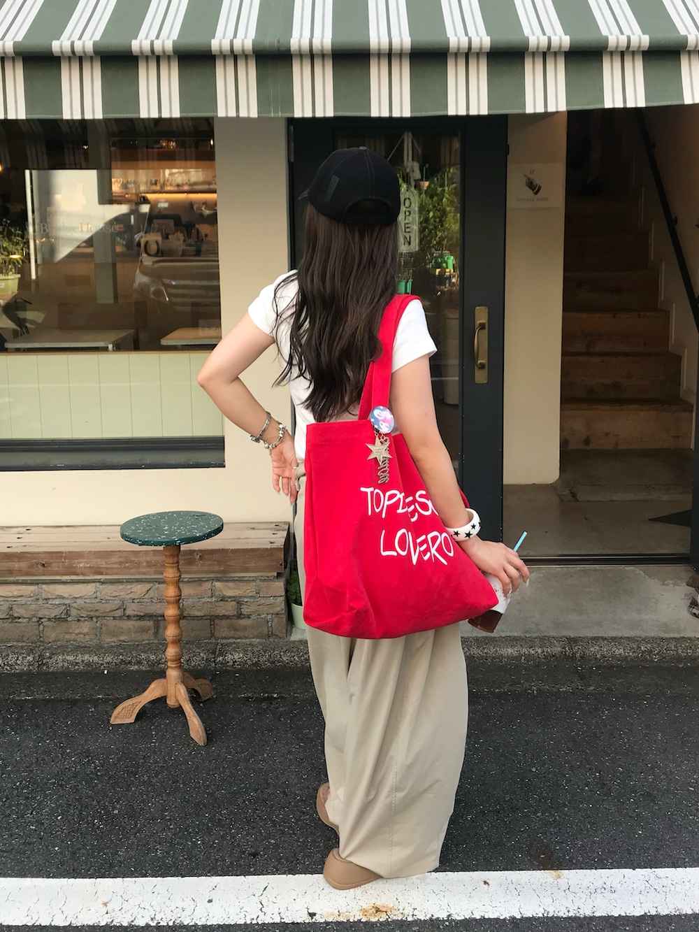 ベージュ系のサンダル、ホワイト系のTシャツ/カットソー、ベージュ系のパンツを着用したレディースの夏コーディネートの2枚目の写真