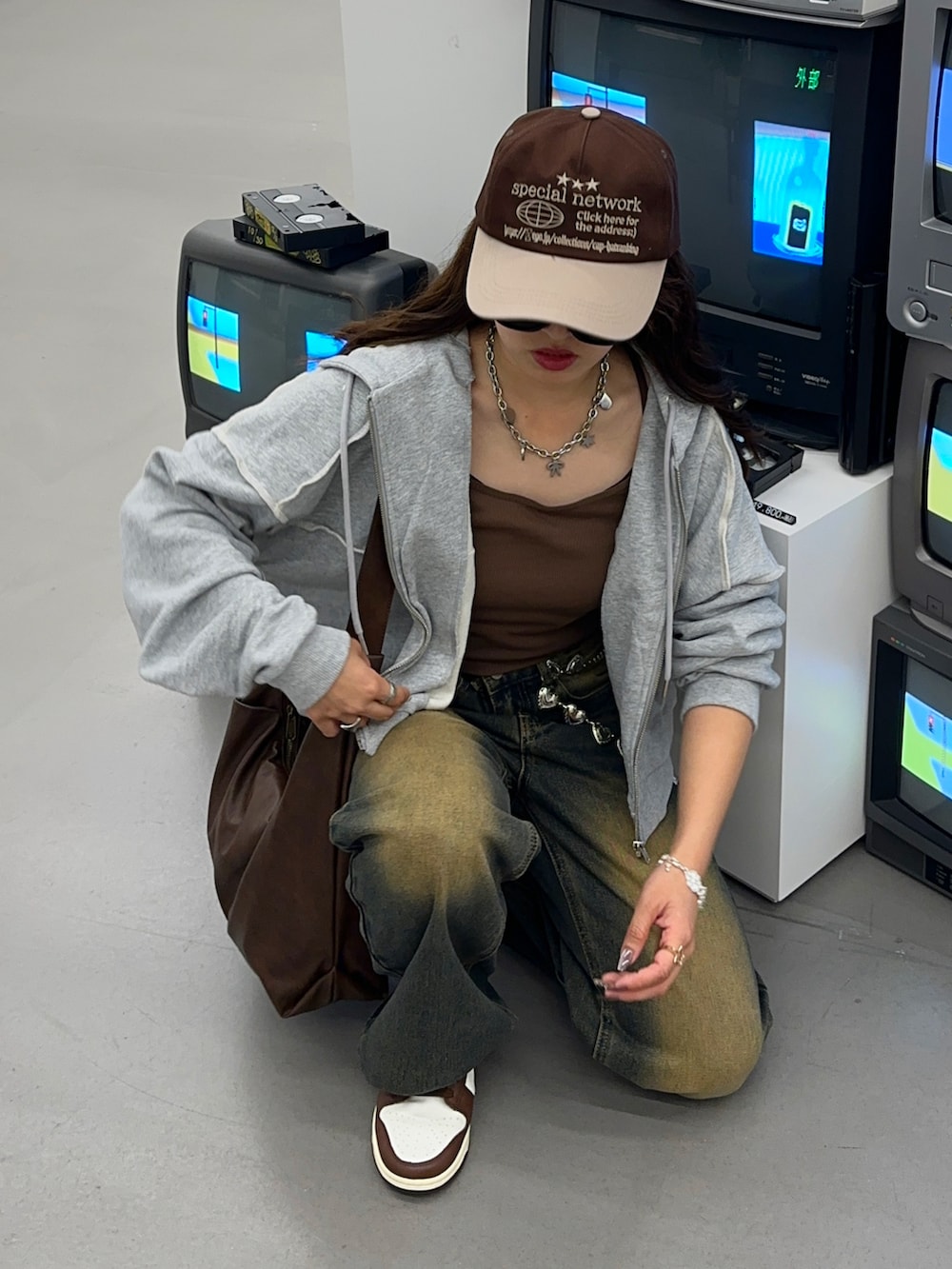 ブラウン系のキャミソール、ブルー系のデニムパンツ、グレー系のパーカーを着用したレディースの秋コーディネートの2枚目の写真