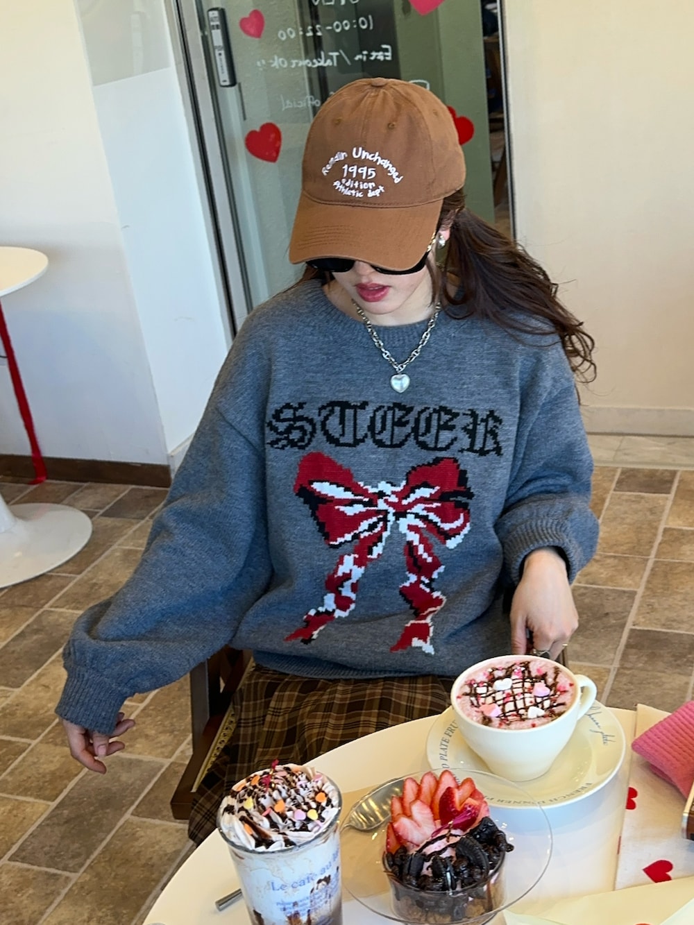 グリーン系のスカート、グレー系のニット/セーター、ブラウン系のシューズを着用したレディースの冬コーディネートの2枚目の写真