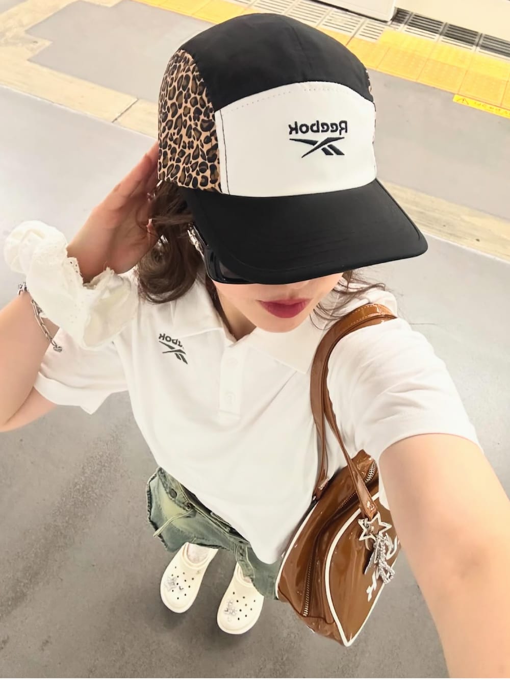 ホワイト系のサンダル、ブラウン系のボストンバッグ、ブルー系のデニムスカートを着用したレディースの春コーディネートの4枚目の写真