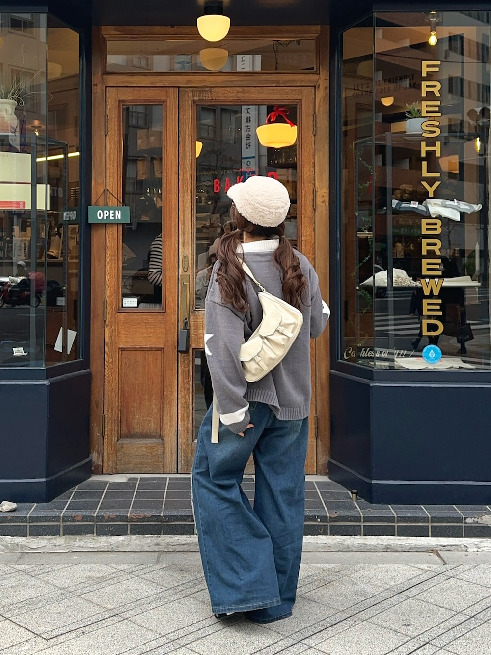 ブラック系のスニーカー、ベージュ系のハンドバッグを着用したレディースの冬コーディネートの3枚目の写真