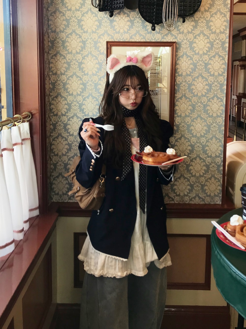 ブルー系のテーラードジャケット、ブルー系のデニムパンツ、イエロー系のハンドバッグを着用したレディースの春コーディネートの4枚目の写真