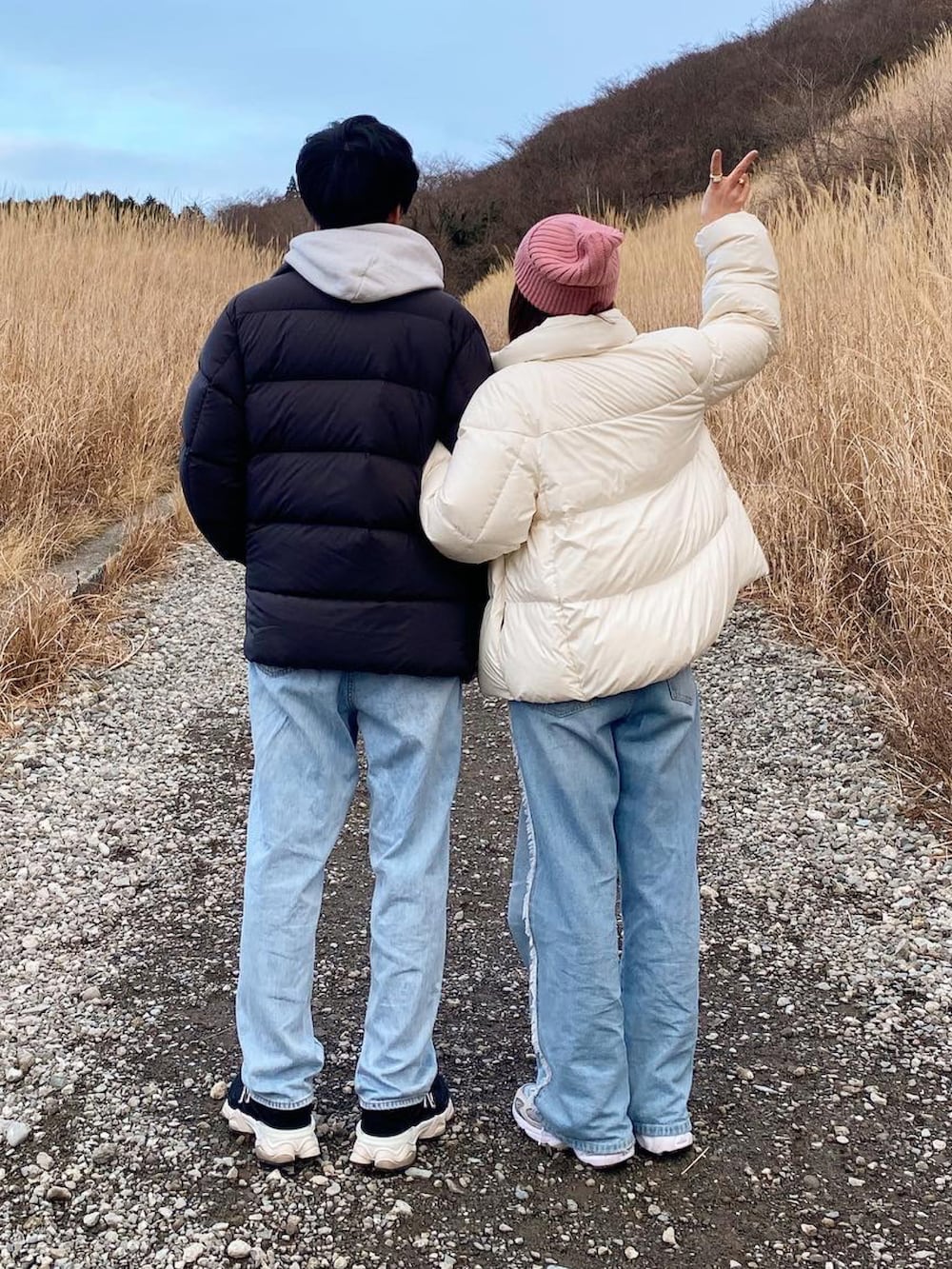 ブラウン系のショルダーバッグ、グレー系のスニーカー、ブルー系のデニムパンツを着用したレディースの冬コーディネートの2枚目の写真