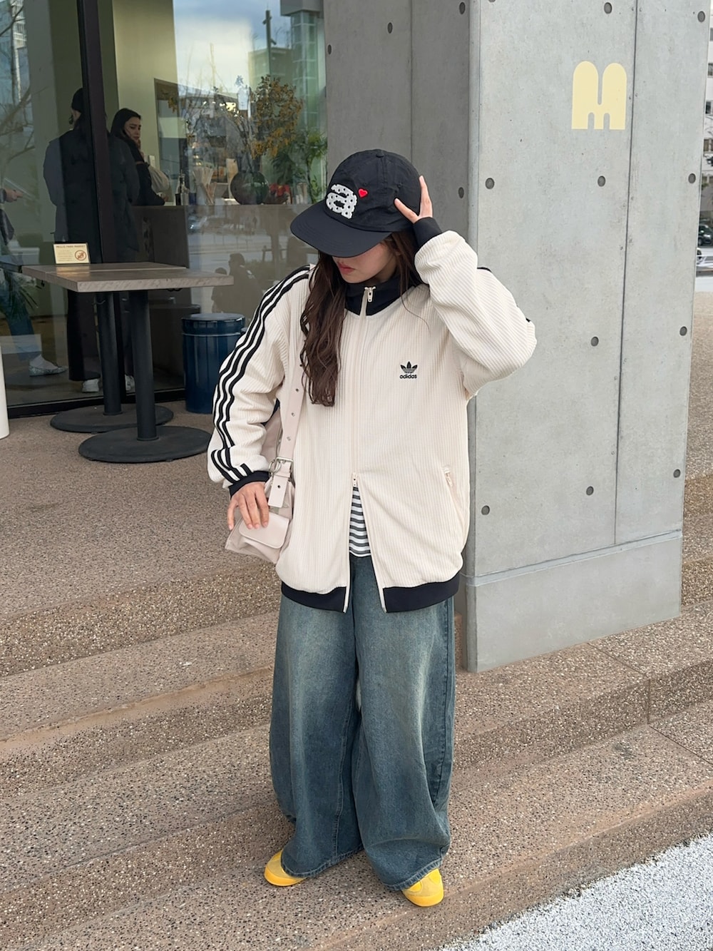 ホワイト系のジャージ、ブルー系のデニムパンツ、イエロー系のスニーカーを着用したレディースの春コーディネートの3枚目の写真