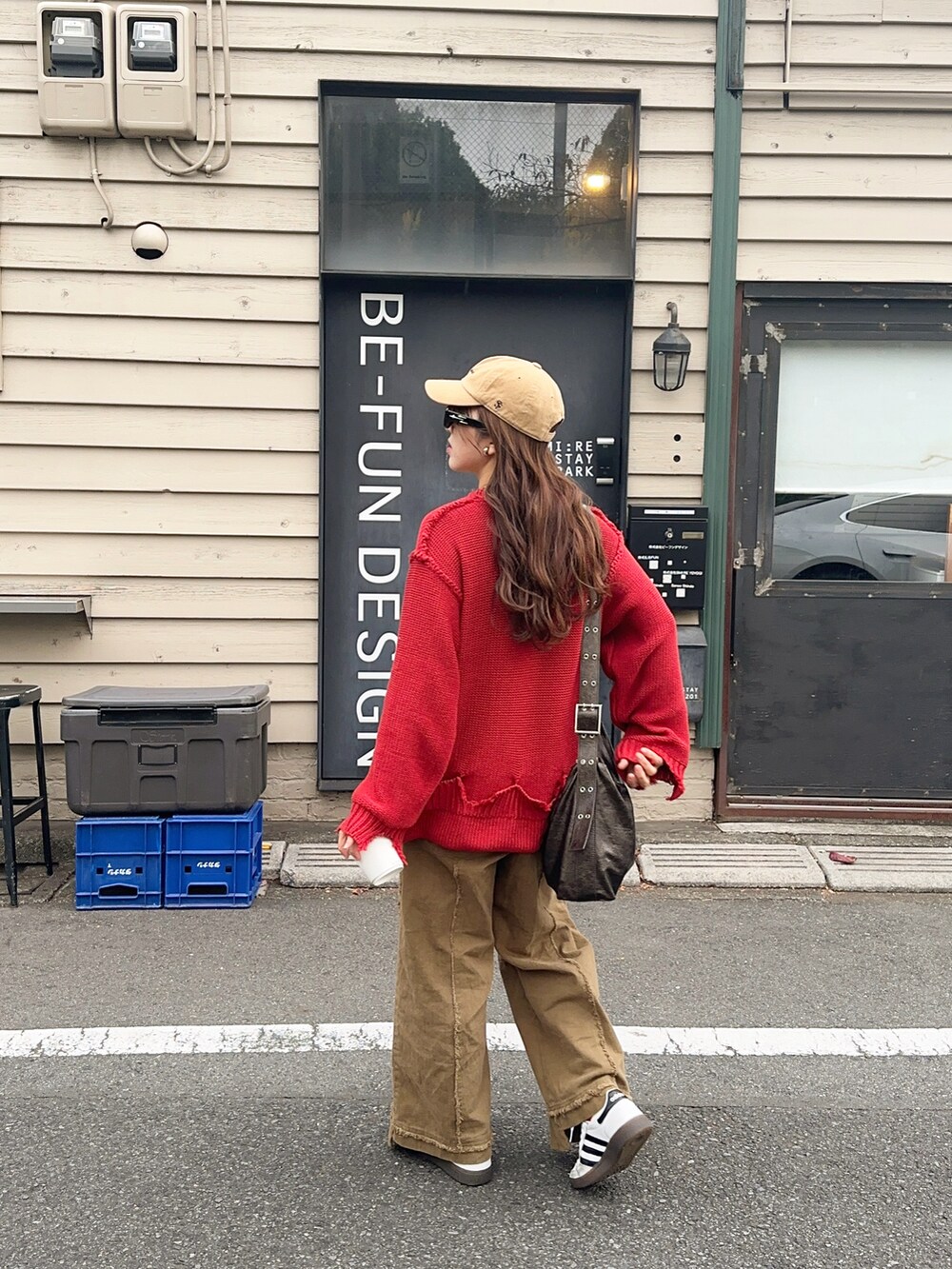 ホワイト系のスニーカー、レッド系のトップスを着用したレディースの秋コーディネートの2枚目の写真