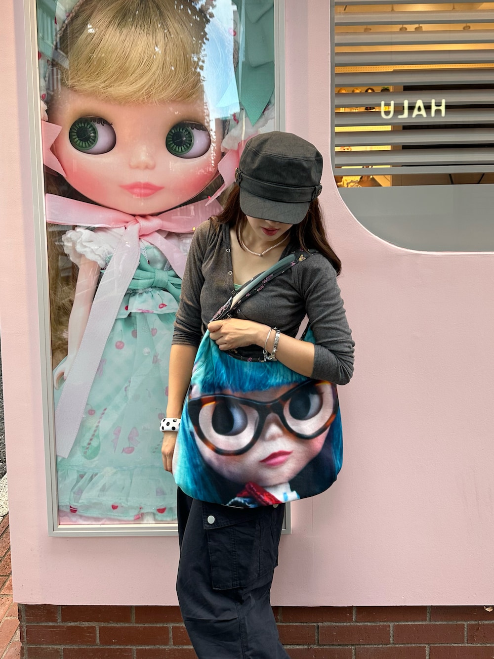 グレー系のトップス、ブルー系のパンツ、ブラック系のスニーカーを着用したレディースの秋コーディネートの2枚目の写真
